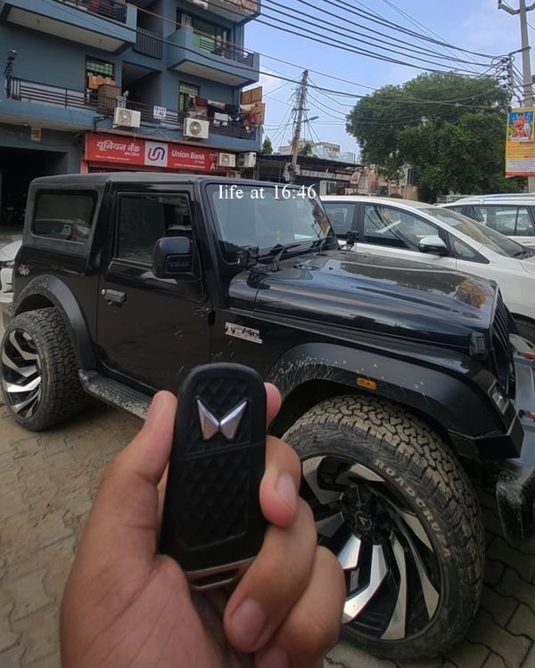 Thar key fob held up in front of the black Thar