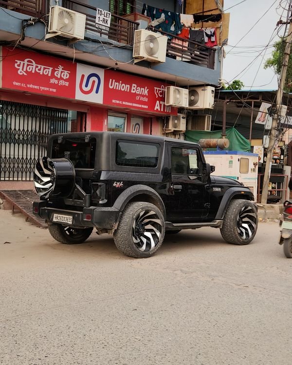Black Mahindra Thar on aftermarket alloys, parked outside a Union Bank branch